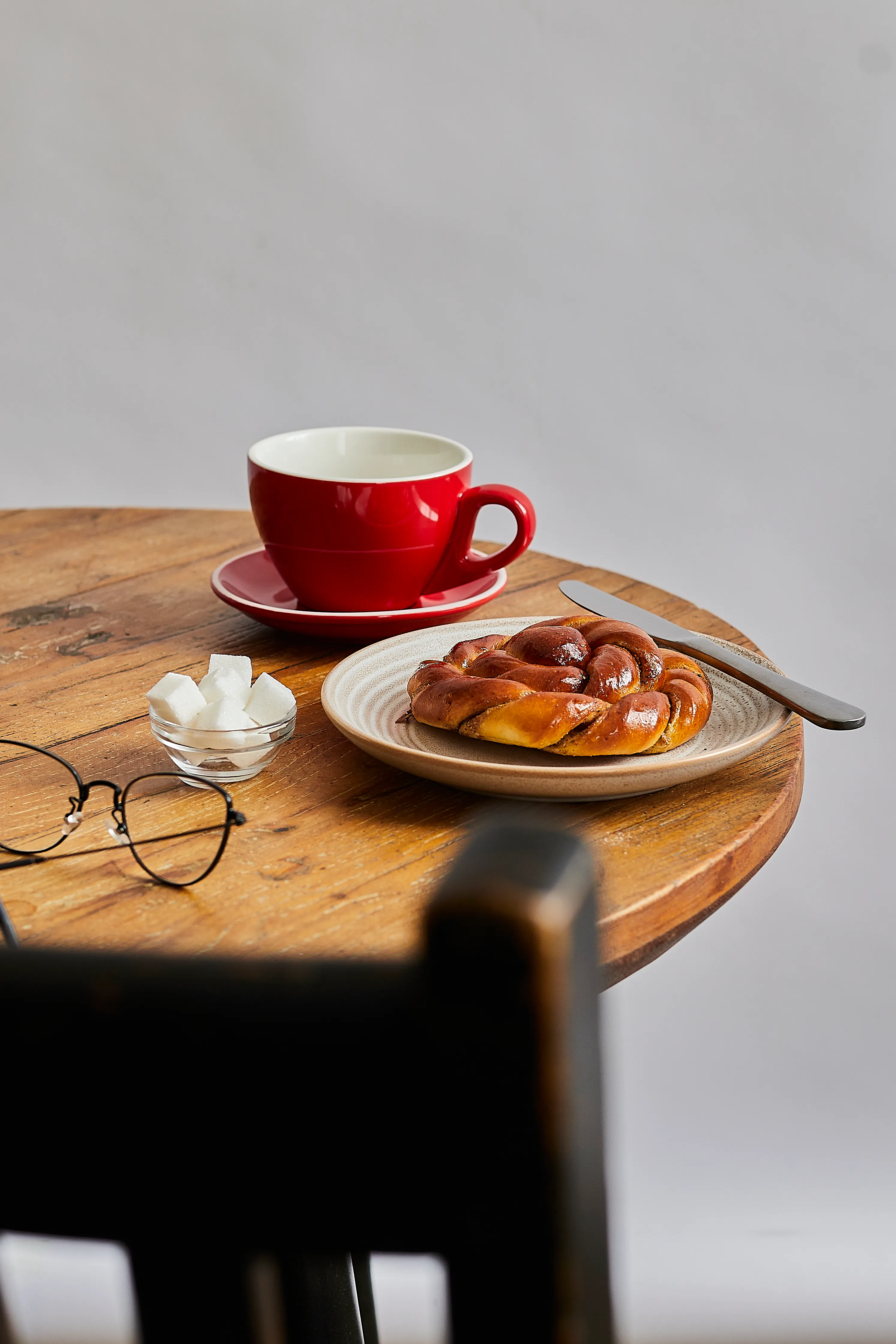Steaming hot coffee with a pastry on a wooden table top