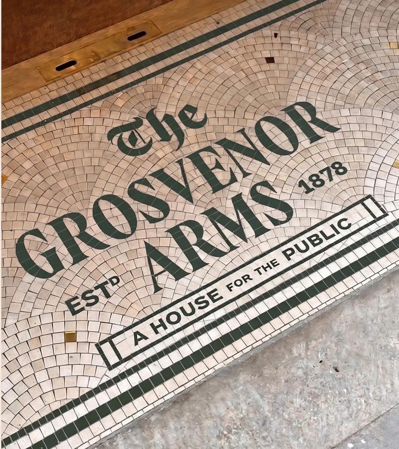 The mosaic threshold at the pub door